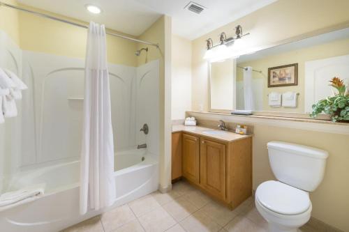 a bathroom with a toilet and a tub and a sink at Beautiful Apartment close to Disney, fully equipped Amazing lake views in Orlando