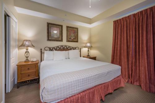 a bedroom with a large white bed with red curtains at Beautiful Apartment close to Disney, fully equipped Amazing lake views in Orlando