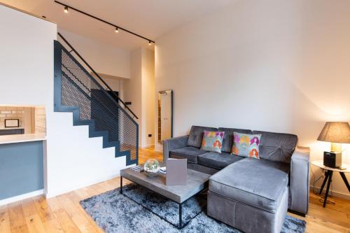 a living room with a couch and a table at Linton Collection - Blackfriars Lofts in Edinburgh