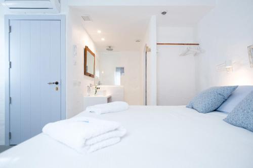 a bedroom with a white bed with towels on it at HOTEL ANHEL in Ferreries