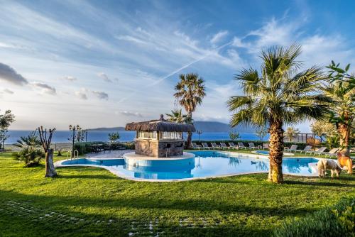 a resort pool with a gazebo and palm trees at Assos Alis Farm Boutique Hotel & Spa in Behramkale