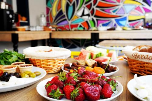 a table topped with plates of fruit and pastries at İsinda Pansiyon in Kas