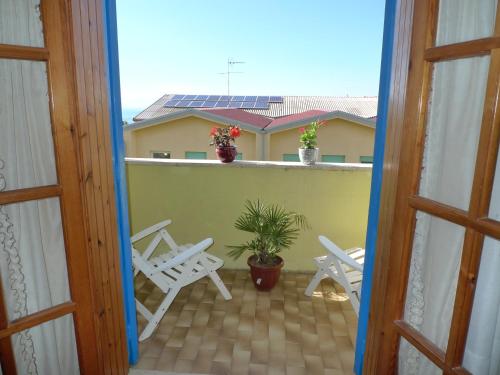 a view of a balcony with chairs and a plant at Hotel Alexander in Tropea