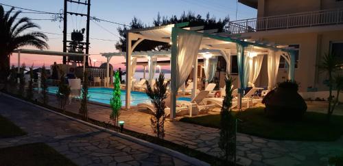 a villa with a swimming pool at night at SUNSET HOTEL in Neos Marmaras
