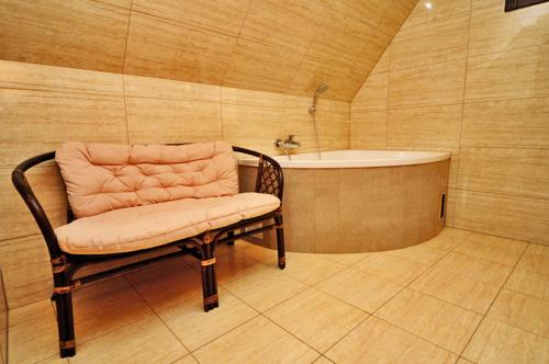 a bathroom with a bench and a bath tub at Willa Ostoja in Świeradów-Zdrój