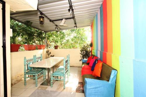a patio with a table and chairs and a colorful wall at Town Hostel Mumbai - AC Dormitory in Mumbai