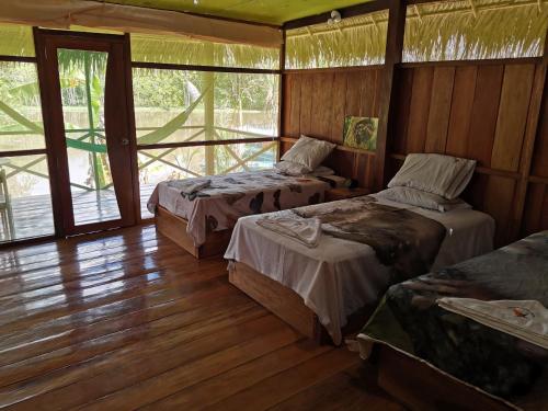 a room with two beds and a wooden floor at Grand Amazon Lodge and Tours - All Inclusive in Paraíso