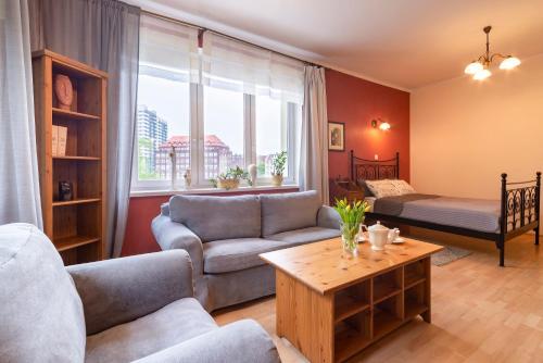 a living room with a couch and a bed at Radunia Canal Apartment in Gdańsk