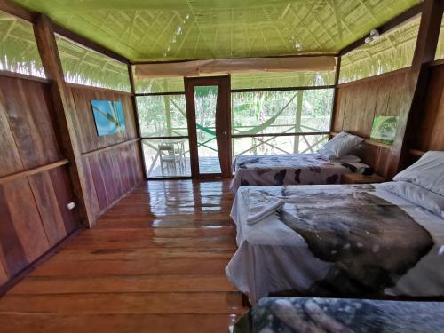 a bedroom with two beds in a room with windows at Grand Amazon Lodge and Tours - All Inclusive in Paraíso