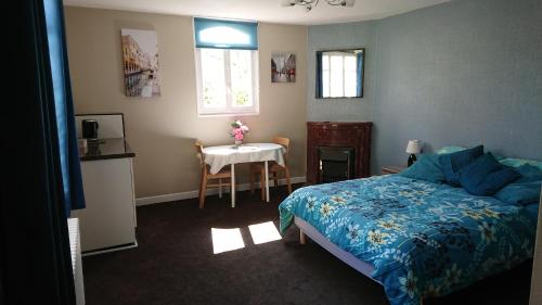 Un dormitorio con una cama y una mesa. en Maison Vuyk, en Nalliers