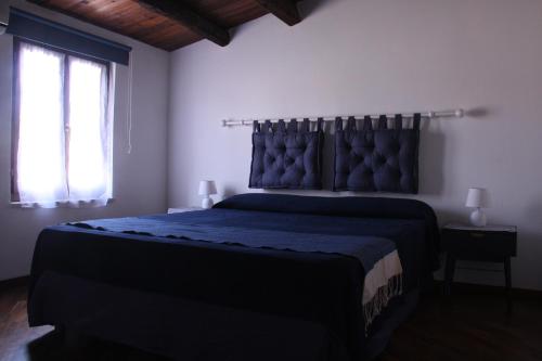 a bedroom with a bed with a blue bedspread and a window at Casa PAN (Percorso Arabo Normanno) in Palermo