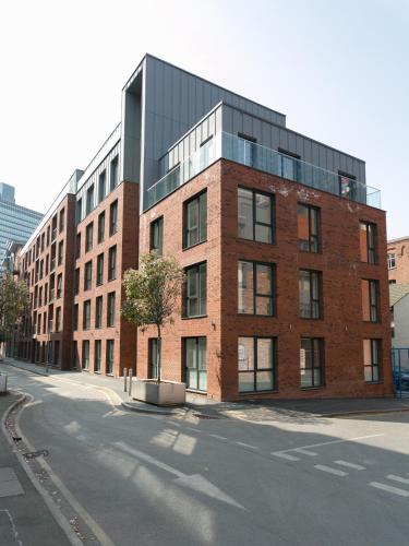 a large brick building on the side of a street at Hilltop Serviced Apartments- Northern Quarter in Manchester