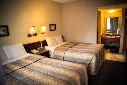 Una cama o camas en una habitación de Langley Hwy Hotel
