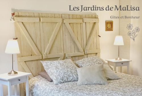 - une chambre avec une porte de grange en bois derrière un lit dans l'établissement Les Jardins de MaLisa - Adulte Only -, à Ferrières-la-Verrerie