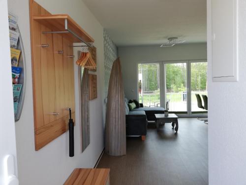 ein Wohnzimmer mit einem Sofa und einem Fenster in der Unterkunft nagelneue Fewo mit Waldblick 10min zur See Igelring21og in Graal-Müritz