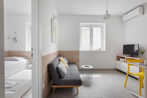 a living room with a couch and a bedroom at Apartments Coast 27 in Podgora