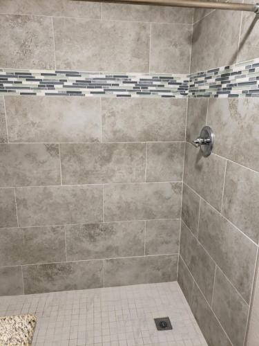 a bathroom with a shower with a tiled floor at Classic Inn and Suites in El Centro