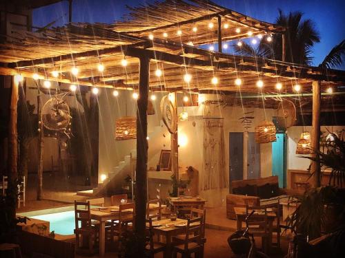 a patio with tables and lights and a pool at LunArena Barefoot Comfort in El Cuyo