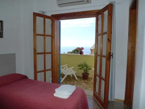 Schlafzimmer mit einer Tür, die auf einen Balkon führt in der Unterkunft Hotel Alexander in Tropea
