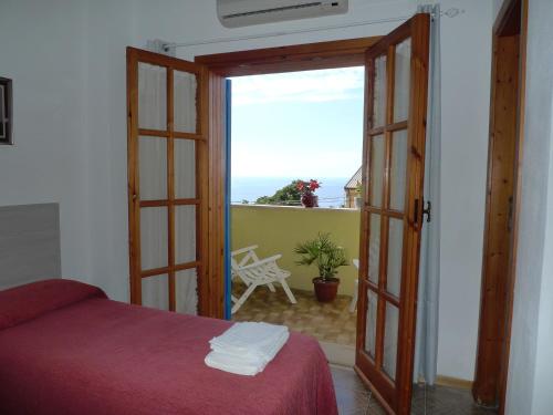 a bedroom with a door open to a balcony at Hotel Alexander in Tropea