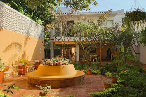 a garden with a bench in the middle of a building at Hotel La Gloria in Mompos