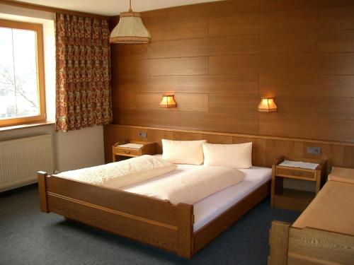 トリンスにあるHaus Maderの木製の壁のベッドルーム1室(大型ベッド1台付)