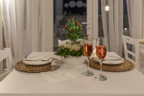a white table with two glasses of wine on it at Petra Bianca in Torre San Giovanni Ugento