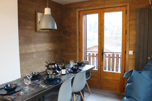 - une salle à manger avec une table et des verres à vin dans l'établissement Sapinette, à Arâches-la-Frasse