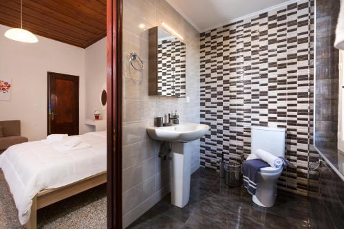 a bathroom with a sink and a bed and a shower at Villa Alexandra in Kissamos