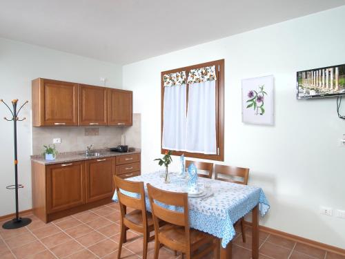 a kitchen with a table and some chairs and a table and a kitchen at Agriturismo Ai Laghi in Pocenia