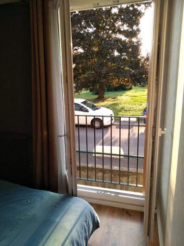 a bedroom with a door open to a view of a car at La Boisselle, chez l'habitant in Saint-Germain-lès-Arpajon