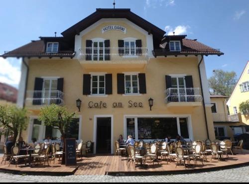 a building with tables and chairs in front of it at Hotel Garni Goldammer in Dießen am Ammersee