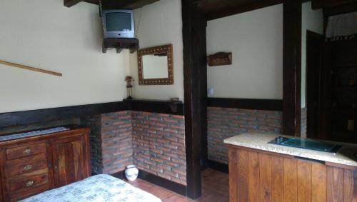a kitchen with a sink and a tv on the wall at Entre Puentes in Puente Viesgo