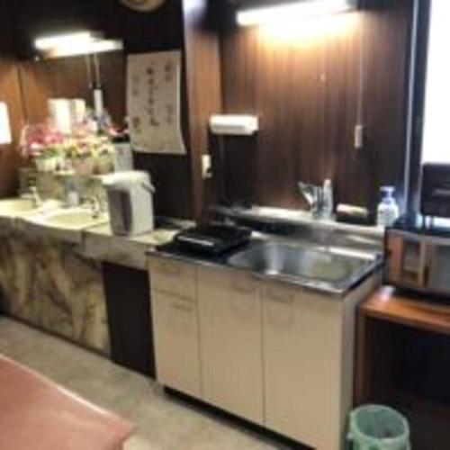 a kitchen with a sink and a counter top at Guesthouse Wanokaze mix domitory / Vacation STAY 32202 in Otaru