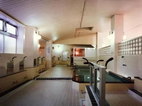 un gimnasio con piscina en un edificio en Guesthouse Wanokaze mix domitory / Vacation STAY 32202, en Otaru