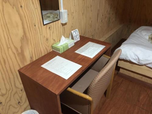 einen Schreibtisch in einem Zimmer mit einem Bett und einem Tisch mit einem Telefon in der Unterkunft Guesthouse Otaru Wanokaze double room / Vacation STAY 32211 in Otaru