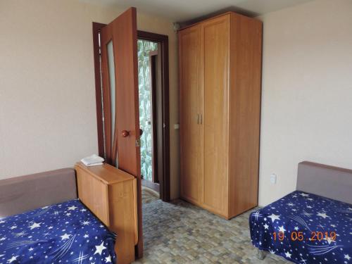 ソルタヴァラにあるDom in Krasnaya gorka с саунойのベッド2台と木製キャビネットが備わる客室です。