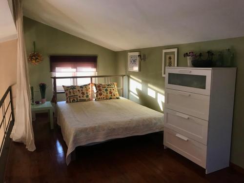 a bedroom with a bed with a dresser and a window at Plane Tree House in Mákri