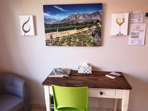 a desk with a green chair and a picture on the wall at Dilisca Guesthouse in Durbanville