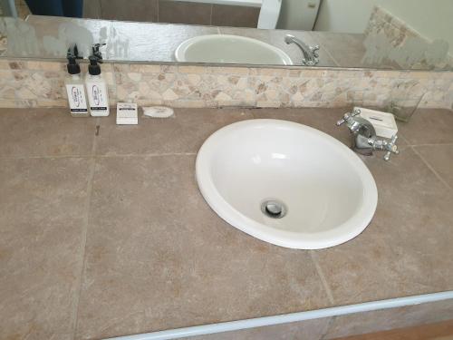 a white sink in a bathroom with a counter at Dilisca Guesthouse in Durbanville
