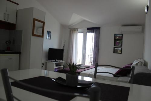 a room with a table and a kitchen with a bed at Apartments Mateljak in Gradac