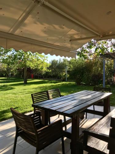 a wooden picnic table with chairs under a tent at Plane Tree House in Mákri