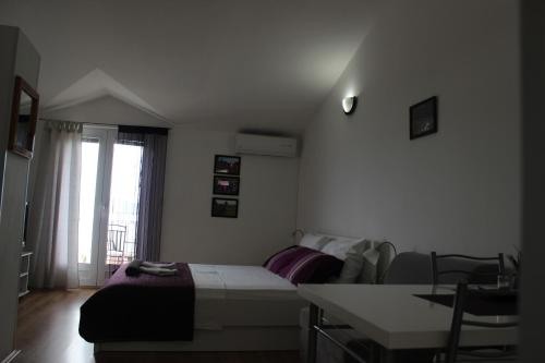 a bedroom with a bed and a desk and a window at Apartments Mateljak in Gradac