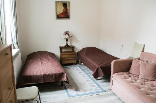 ein Wohnzimmer mit 2 Betten und einem Sofa in der Unterkunft Vintage Style spacious apartment in Klaipėda