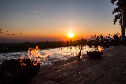 aburning fire pit with the sunset in the background at Bio Habitat Hotel in Armenia