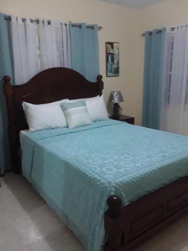 a bedroom with a bed with a blue comforter at Barrianna Villa in Montego Bay