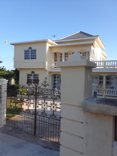 a white house with a gate and a fence at Barrianna Villa in Montego Bay