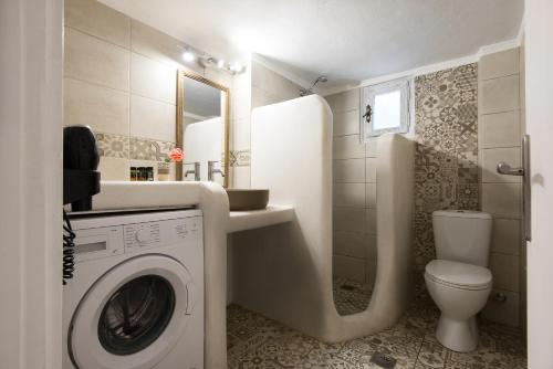 uma casa de banho com uma máquina de lavar roupa e um WC em Sunny Guest House New Port Mykonos em Tourlos