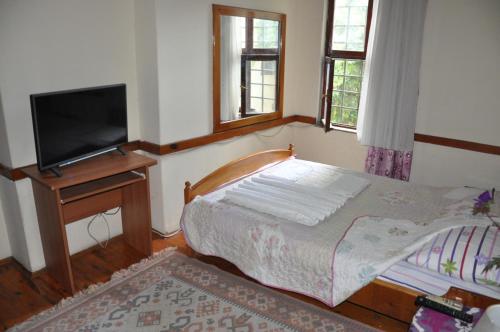 a bedroom with a bed and a flat screen tv at Kont Pension in Antalya