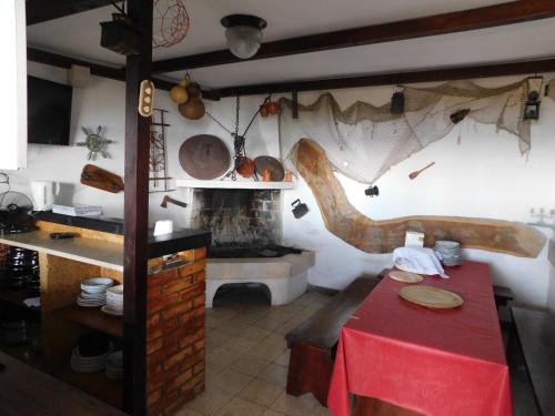 a kitchen with a red table and a fireplace at Beach Villa Bozikovic in Podstrana